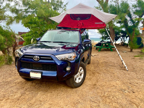 Blue Toyota 4Runner with rooftop tent, set up for beach camping. A unique RV rental for island adventures in Hawaii.