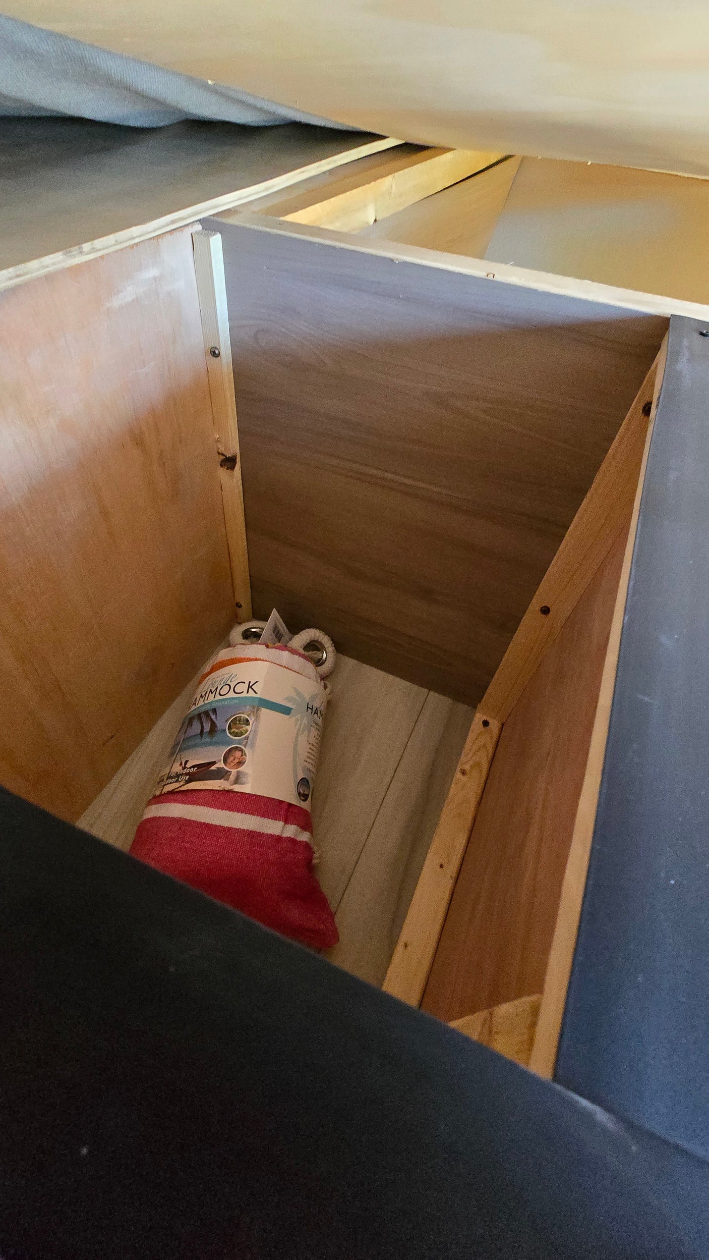 RV rental storage: An open wooden compartment with a packaged hammock inside, ready for your trip.
