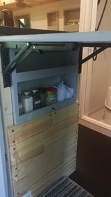 RV rental: Small kitchen area with spice shelf, folded towels, and a collapsible counter-table for efficient use of space.