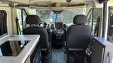 Spacious RV rental interior looking to the cockpit; note front seats, dashboard tablet, and side kitchen counter.