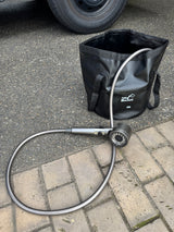 A black 20L Folding Bucket and portable shower system, ideal for RV rental adventures and outdoor cleanups.