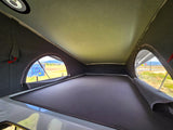 Cozy pop-top RV interior perfect for an rv rental adventure. Features elevated sleeping and scenic views.