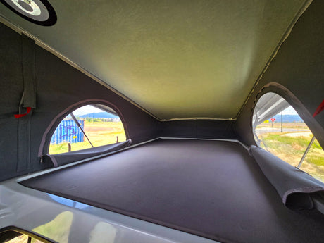 Cozy pop-top RV interior perfect for an rv rental adventure. Features elevated sleeping and scenic views.