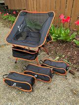 Sportneer portable chair & compact cases on pavement. Ideal outdoor gear for an RV rental trip, near tulips by a fence.