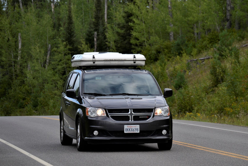  showcasing a unique RV rental alternative for camping adventures.|Dark grey minivan camper with a rooftop tent — photo 2