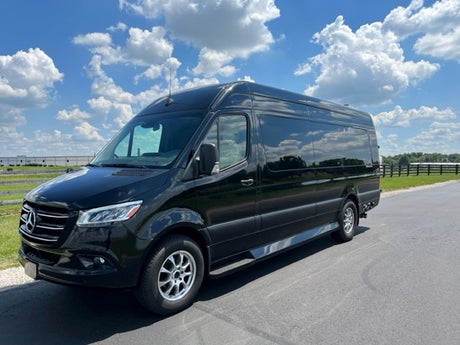Black Mercedes-Benz Sprinter RV rental van. This versatile luxury vehicle is parked on asphalt under a bright blue sky.