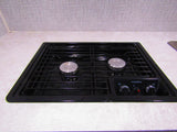 A Dometic two-burner stovetop, integrated into a light countertop, is ready for cooking in this RV rental kitchen.
