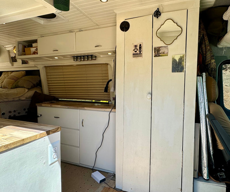  plus a comfy bed and smart storage solutions.|Interior of a compact RV rental kitchen featuring a wood counter — photo 4