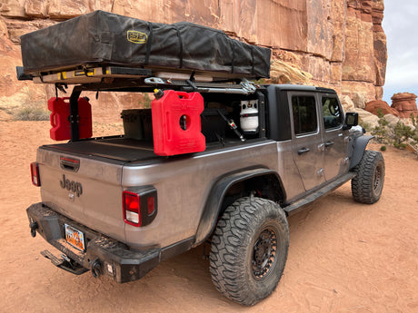 This adventure-ready Jeep Gladiator, equipped for overlanding with a rooftop tent, offers an RV rental alternative for desert camping.
