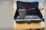 Enjoy outdoor cooking with our Coleman camp stove, perfect for your RV rental adventure. A saucepan sits on the burner.