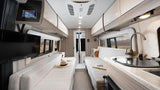 Spacious RV rental interior featuring a modern kitchen, living area with TV, and comfortable sleeping benches.