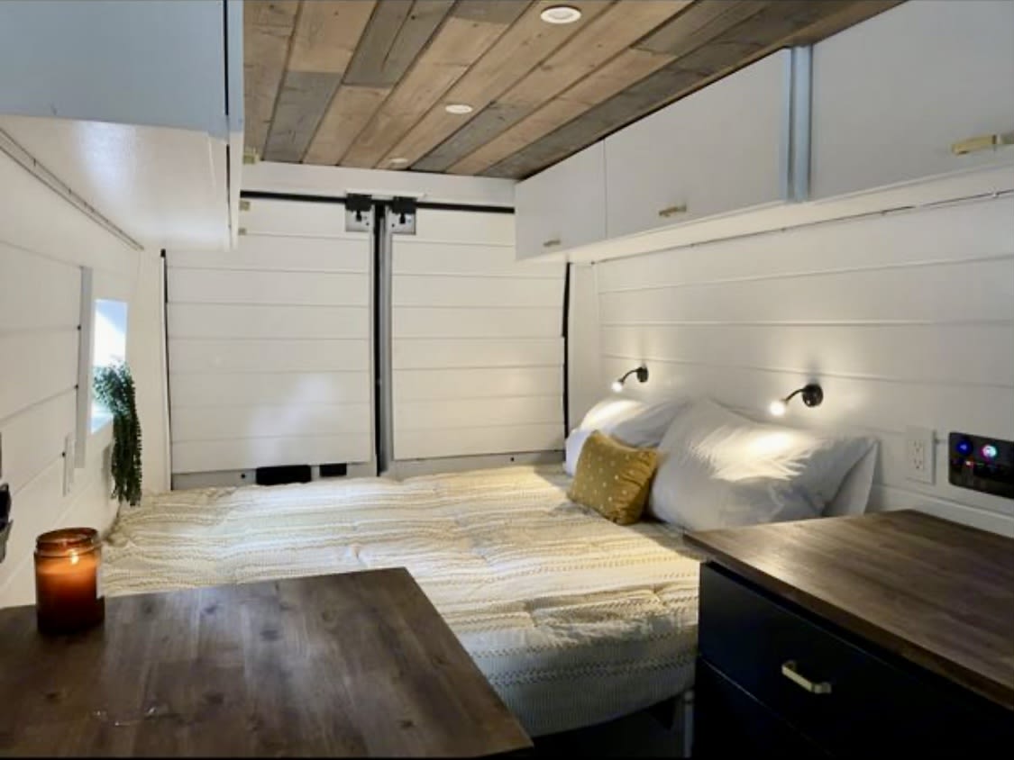  and a dining table.|Bright RV rental interior featuring a wood ceiling — photo 5