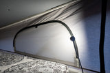 Cozy RV rental pop-top interior showing bed, zippered window, and subtle lighting. Perfect for comfortable camping.