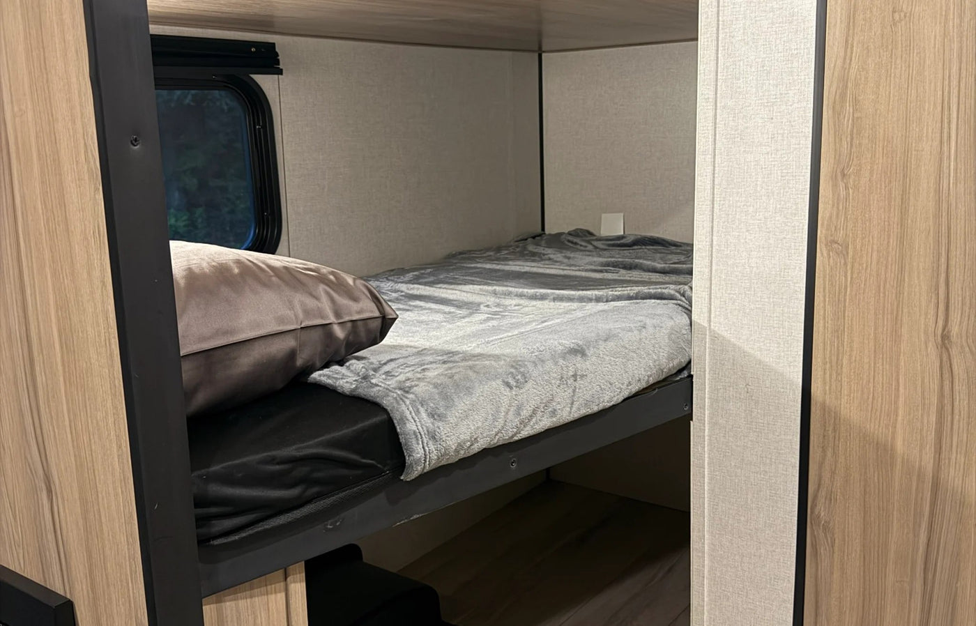  parked in a woodsy setting with a bike.|RV rental kitchen: compact space with sink — photo 9