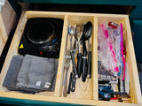 Efficient RV rental drawer: hot plate, cooking utensils, and towels, with small travel supplies, ready for adventure.