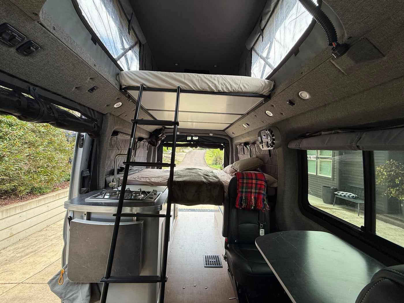 Explore this modern RV rental interior featuring a kitchen, bunk beds, and comfortable seating area. Ideal for travel. — photo 18