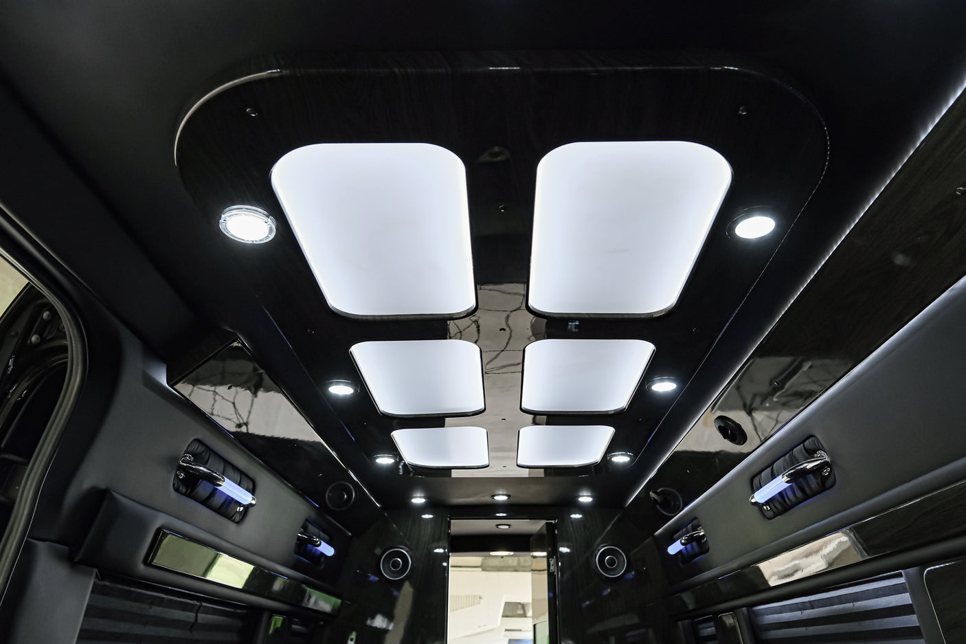 Step inside this luxurious RV rental: elegant dark wood-grain ceiling, illuminated panels, and comfortable padded walls.