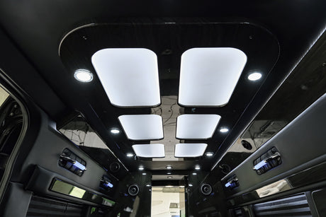 Step inside this luxurious RV rental: elegant dark wood-grain ceiling, illuminated panels, and comfortable padded walls.
