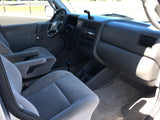 Spacious RV rental interior showing light gray front seats, dashboard, and steering wheel for your next road trip.