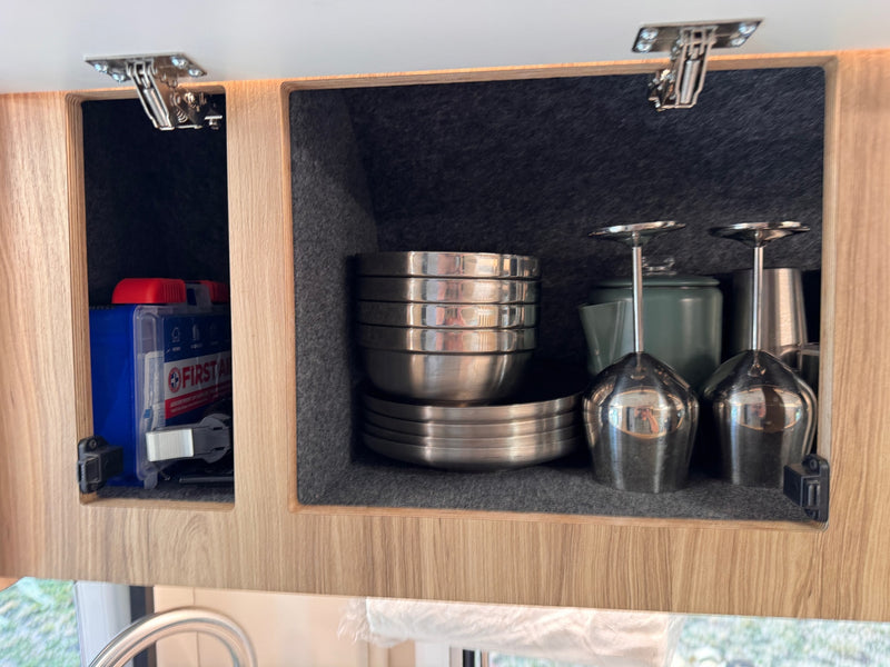 RV rental interior: open cabinets revealing neatly stored kitchenware and a first aid kit. — photo 20