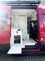 Red camper van rv rental with open side door showing its light, customized interior, ready for travel and adventure.