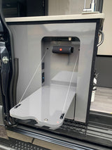 RV rental's clever side entry: fold-down table, JBL speaker, and power outlets for outdoor kitchen utility.