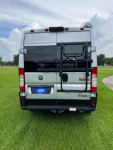 Rear view of a silver Thor Rize camper van, ideal for rv rental. Features include a Thule bike rack and Camping World license plate.