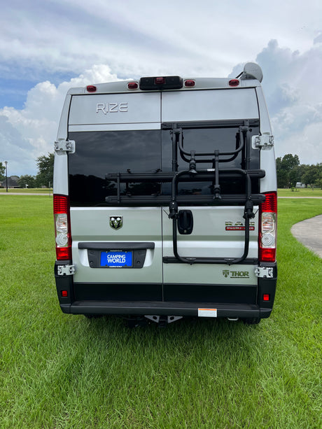 Rear view of a silver Thor Rize camper van, ideal for rv rental. Features include a Thule bike rack and Camping World license plate.