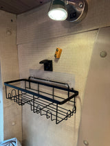 RV rental interior: wall-mounted storage basket, QC 3.0 USB charger, and overhead light for an organized space.