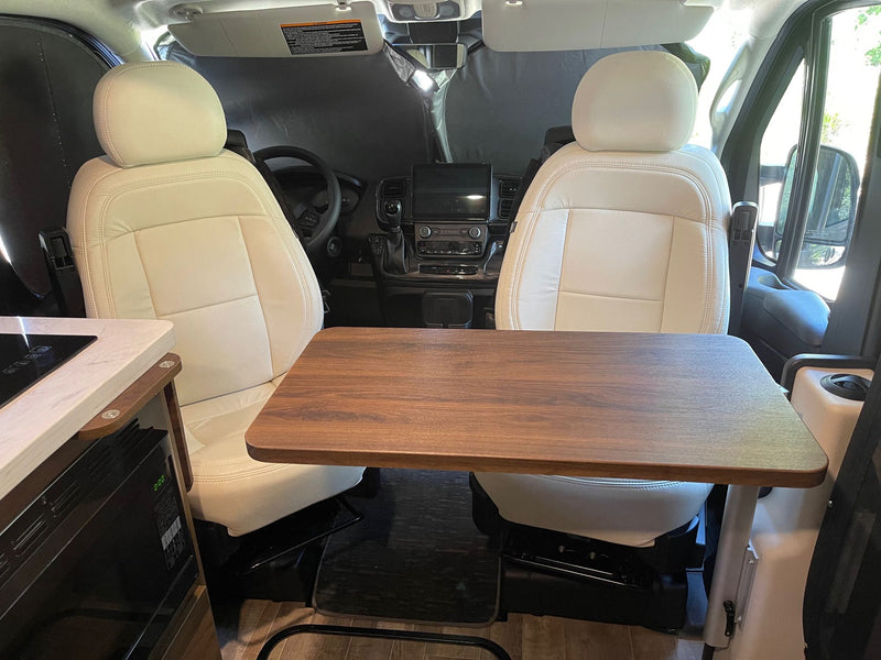  and a small kitchenette area.|Dark grey Winnebago Travato RV rental shining at sunset in a gravel RV park. Features a ladder — photo 13