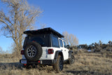 White Jeep Wrangler with a rooftop tent, an ideal RV rental for off-road camping and adventure.