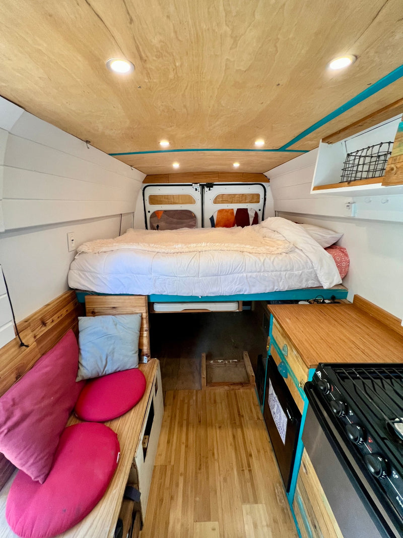  and custom teal & wood cabinets. Perfect for camper adventures.|Cozy RV rental interior with elevated bed — photo 8