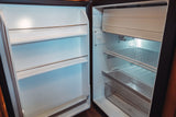 This open, clean, and empty mini-fridge in an RV rental features wire shelves, a freezer, and is ready for your food.