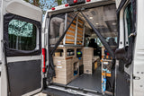 RV rental camper van's spacious rear interior, featuring a mesh screen, versatile storage, and water hookup.
