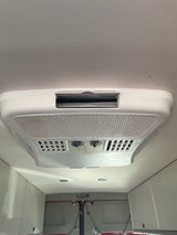 A white Dometic air conditioner unit is seen on the ceiling of an RV rental, providing essential climate control.