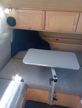 RV rental interior: cozy seating, adjustable table, and overhead storage for a comfortable mobile experience.