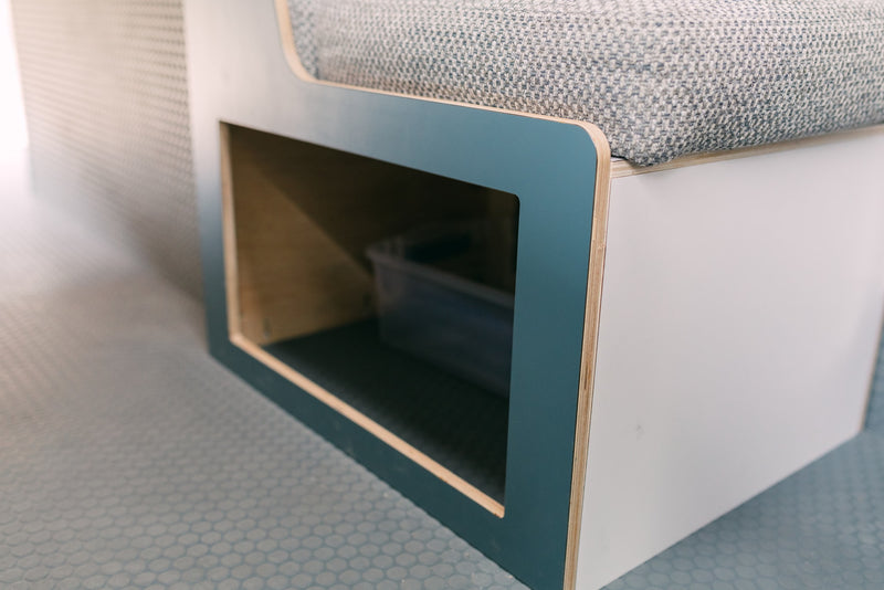 RV rental interior: A modern bench seat with a patterned cushion and a practical open storage cubby, ideal for small spaces. — photo 17