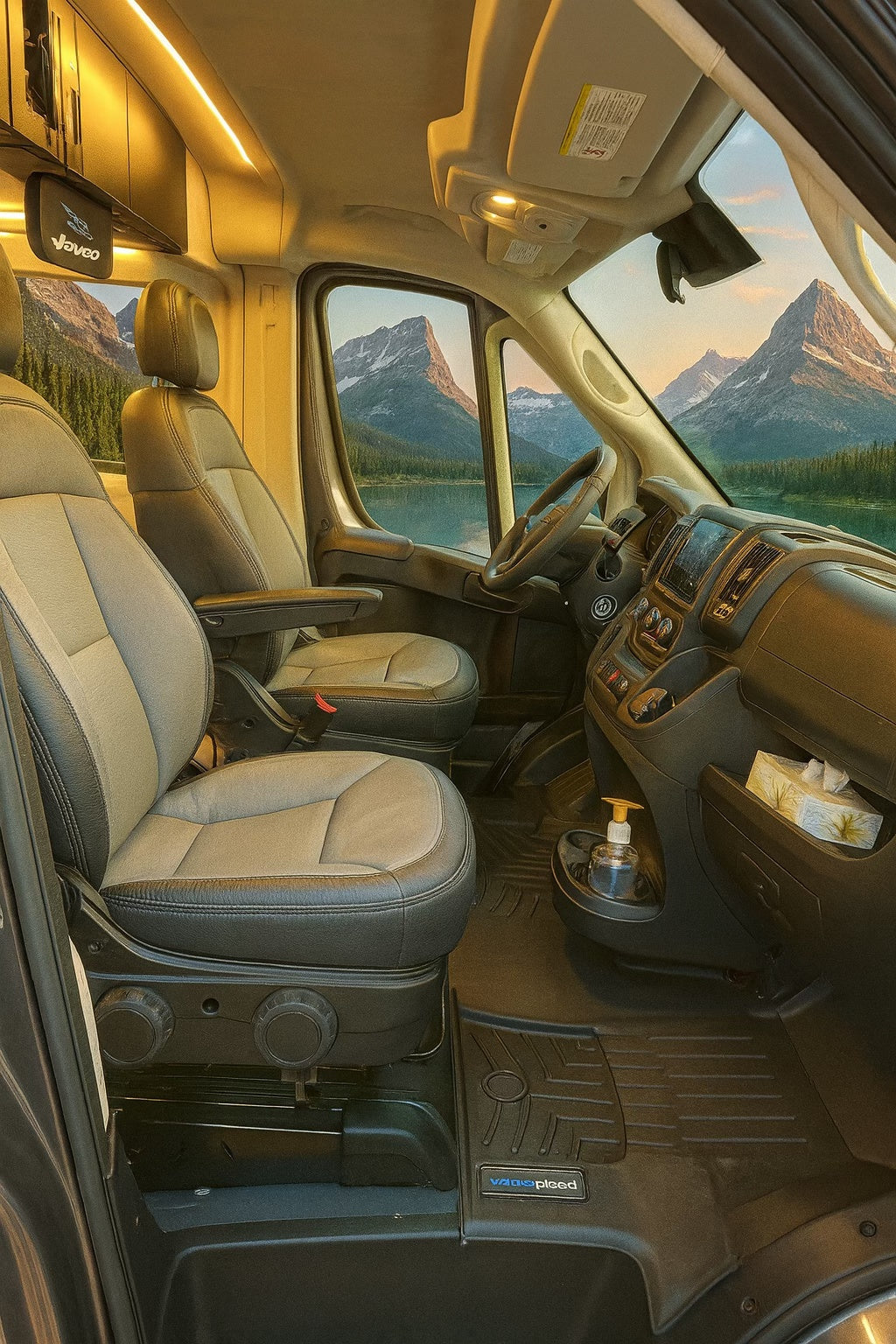 Comfortable RV rental interior: driver's cockpit, mountain & lake views, hand sanitizer, and fitted floor mats.