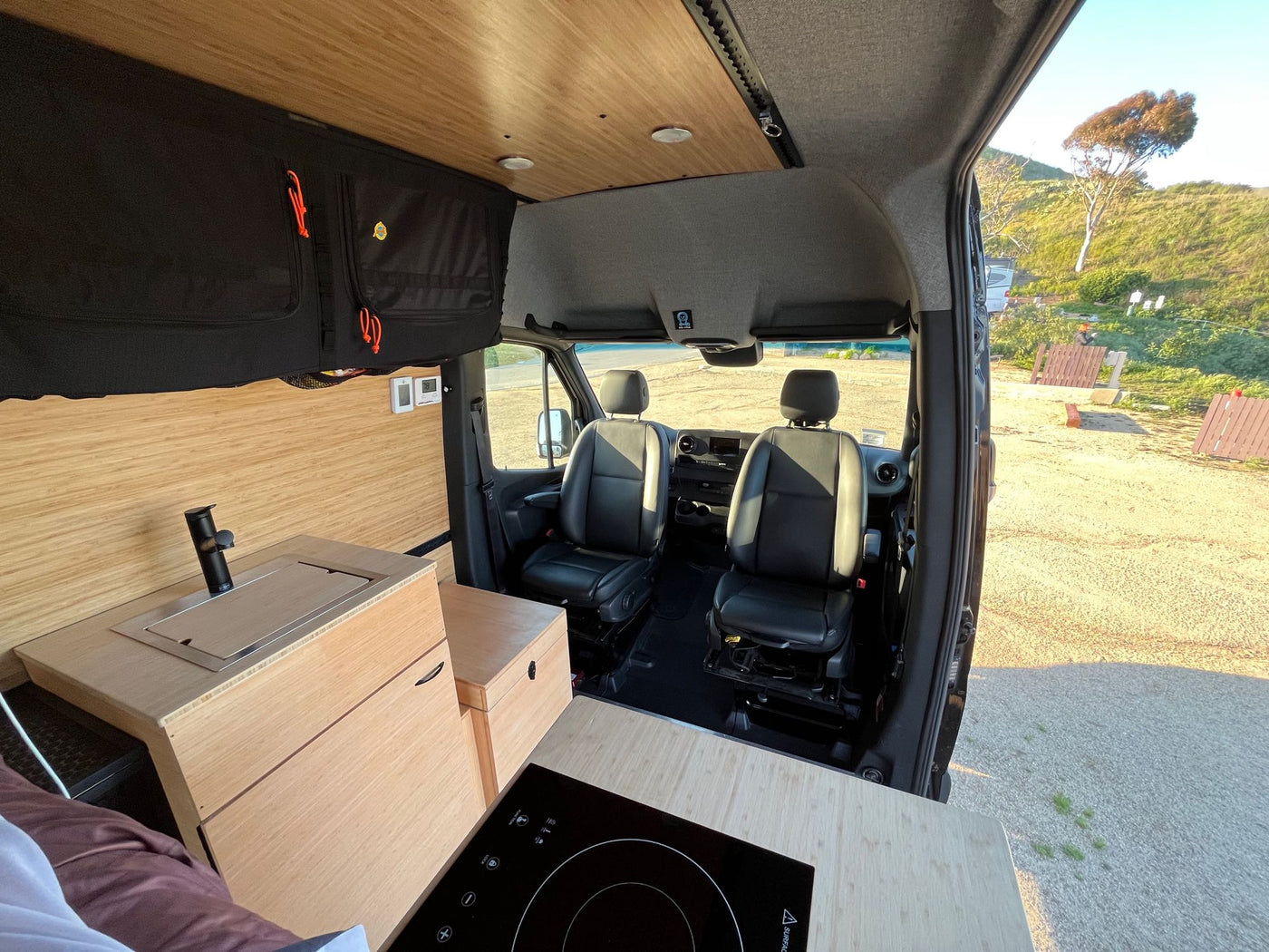 Spacious RV rental interior with a kitchenette, front seats, and a view of the outdoors, perfect for road trips. — photo 4