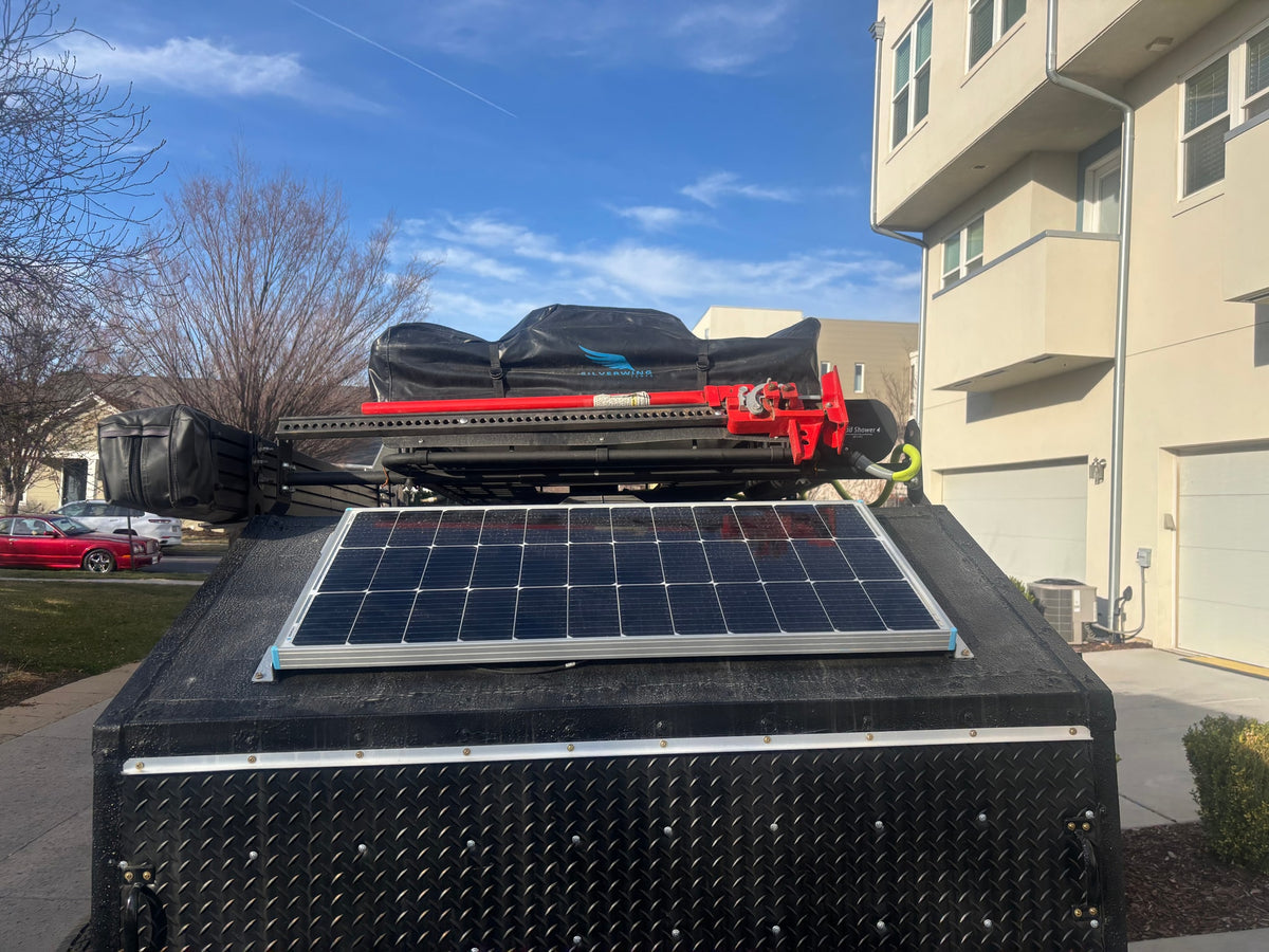  and ladder. Ideal for RV rental adventures.|Rear view of an RV rental camper with a black rooftop tent & colorful stripes — photo 13