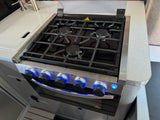 Modern RV rental kitchen with a sleek gas stove, oven below, and three burners with cast iron grates. Knobs feature blue LED lights.