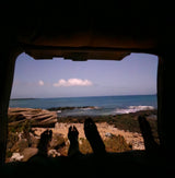 RV rental view: feet up, gazing at the rocky beach & calm ocean from inside. Perfect peace.