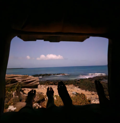 RV rental view: feet up, gazing at the rocky beach & calm ocean from inside. Perfect peace.