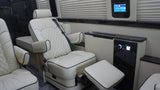Premium RV rental interior with cream captain's chairs, footrest, and integrated climate/audio controls for ultimate comfort.