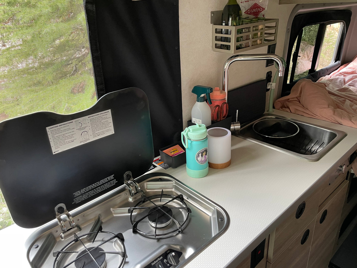 RV rental kitchen: a functional space with stove, sink, countertop, and essentials for preparing meals on the road.