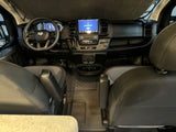 Interior view of an RV rental van's modern front cabin, showing the dashboard, steering wheel, and large infotainment screen.