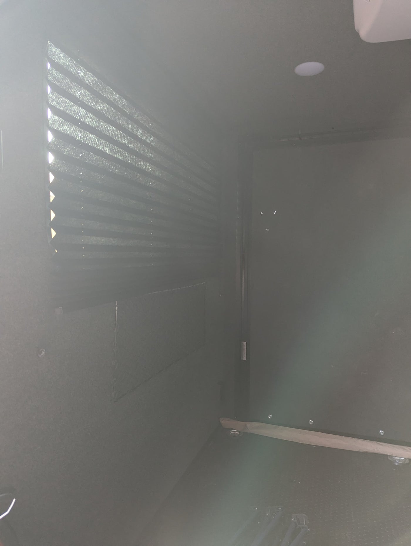 Inside an RV rental: View of a bright window with pleated blinds, recessed ceiling light, and dark, textured interior. — photo 7