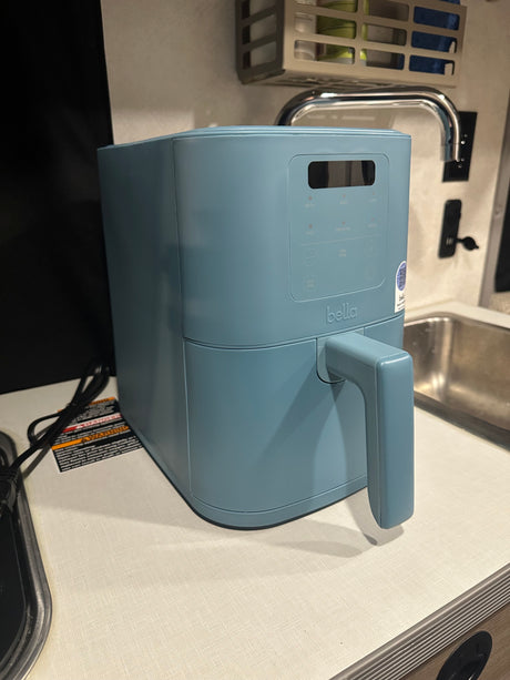 Compact blue Bella air fryer on an RV rental kitchen counter with sink and faucet. Perfect for travel cooking.