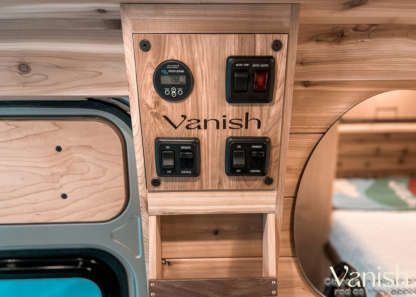 RV rental wood-paneled control panel: Victron battery monitor (79.8%), water pump, heater, and light switches.