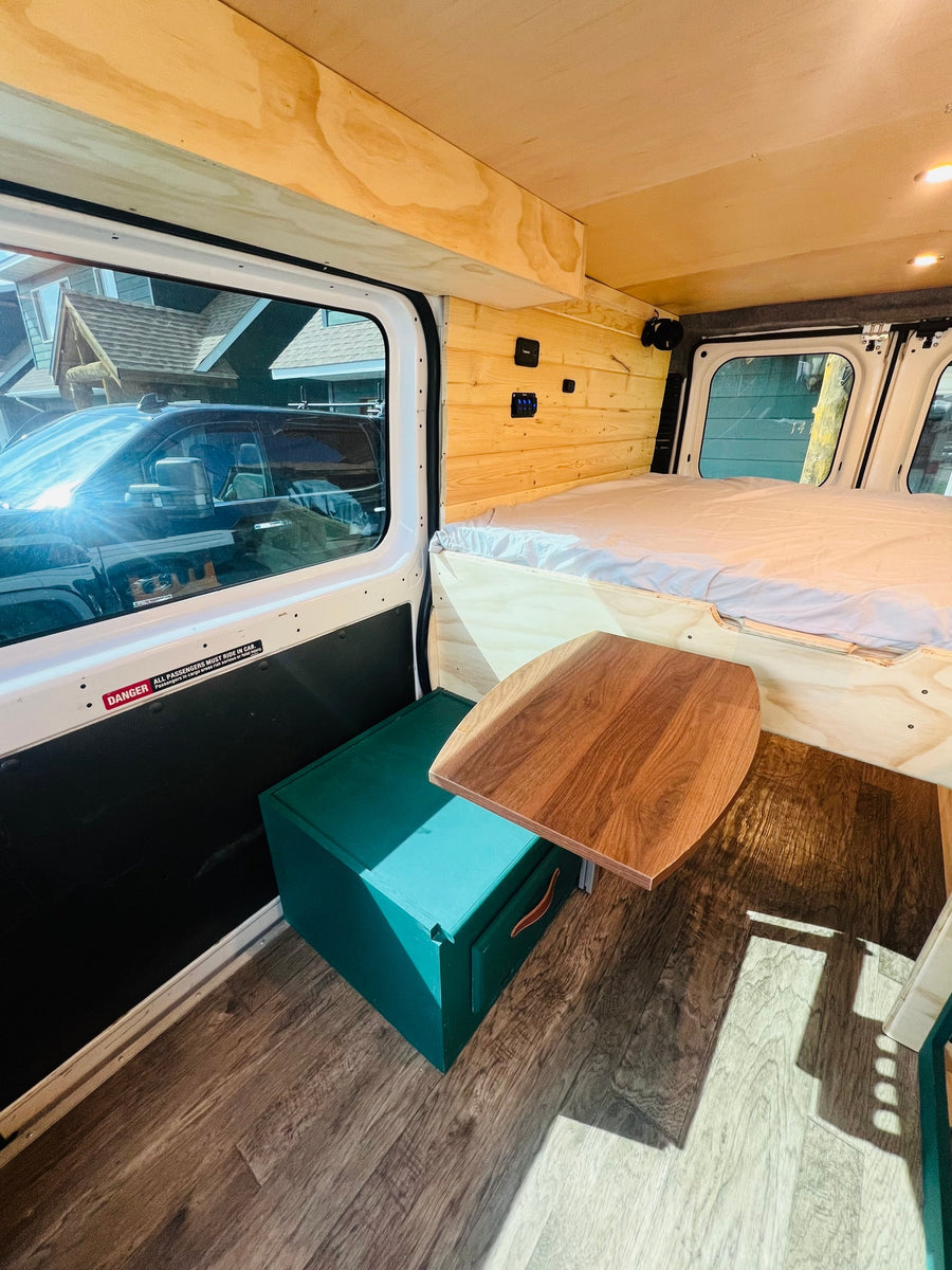  and various wildlife.|White RV rental camper van with extended awning at campsite #6. Two dogs enjoy the sunny mountain setting.|Inside a custom rv rental camper van
